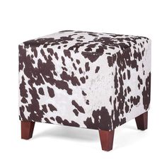 a cow print ottoman with wooden legs