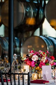 the table is set with wine glasses and flowers