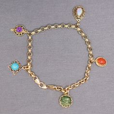 "Multi-Gemstone Dangling Charm Bracelet on Rolo Chain in 14k Yellow Gold This pretty and playful charm bracelet features five stations with gemstone charms, each different and set in their own gold mountings.  The opal charm features a 8.59 x 5.75mm natural opal, the coral in the coral charm measures about 8.47 x 5.50mm, the jade in the jade station measures about 10.5mm in diameter, the turquoise in the turquoise station measures about 6.5mm, and the amethyst measures about 6.2mm.  The stones a Yellow Gold Charm Bracelet With Dangle Shape, Yellow Gold Charm Bracelet With Dangling Charms, Yellow Gold Charm Bracelet Fine Jewelry, Fine Jewelry Yellow Gold Charm Bracelet, 14k Yellow Gold Charm Bracelet With Dangling Charms, Yellow Gold Fine Jewelry Charm Bracelet, 14k Gold Charm Bracelet With Dangling Charms For Gift, 14k Gold Charm Bracelet With Dangling Charms As Gift, 14k Gold Charms Bracelet Fine Jewelry