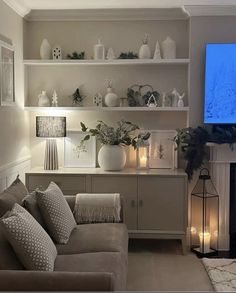 a living room filled with furniture and a flat screen tv mounted on the wall above a fireplace