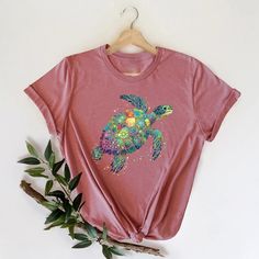 Sea Turtle Shirt, Save the Turtles, Traveler T-Shirt, Animal Lover T-Shirt, Trip Gift, Beach Life Shirts, Love  Turtle Shirt, Adventure Shirt, Turtle Shirt for Women, Love Turtle Shirt, Sea Turtle Shirt, Birthday Gift, Turtle Shirt Gift for Women ➤HOW DO I KNOW WHAT SIZE FITS ME BEST To See Our Size Chart, Please Make Sure To Scroll Through The Photos. The Measurements For Our Shirts Are Listed There As Well. These Are A Unisex Fit, So They Will Be Looser If You Order Your Normal Women's Size. For A More Fitted Look, Most People Will Size Down. Please Keep In Mind That Our Size Chart Measurements Are Not in Circumference. ➤EASIEST WAY TO ORDER 1. First, Make Sure That You Have Read All Relevant Information. You Have Scrolled Through All Of The Photos 2. Once That Has Been Completed, Pick Y Multicolor Cartoon Print Beach Tops, Cotton Cartoon Print Top For Beach, Vacation Crew Neck T-shirt With Cartoon Print, Colorful Turtle, Sea Turtle Shirt, Save The Turtles, Animals Lover, Turtle Shirts, The Turtles