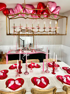 the table is set for valentine's day with pink and red decorations