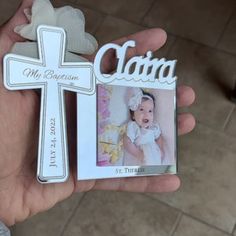 a person holding up a small cross with a picture on the front and back of it