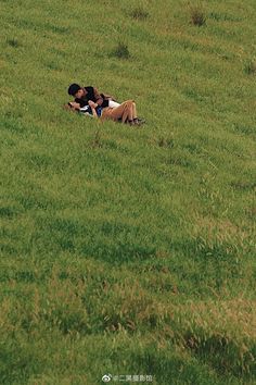 two people are laying in the grass