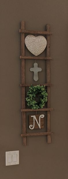 a wooden shelf with a heart and letter n on it next to a light switch