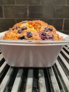 a casserole dish sitting on top of an oven rack filled with blueberries