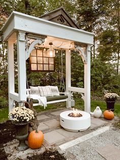 a white bench sitting under a gazebo next to pumpkins