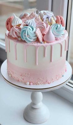 a pink and white cake sitting on top of a window sill