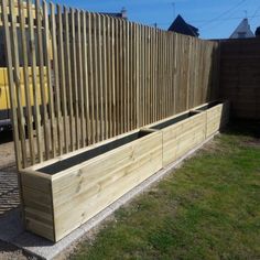 a wooden planter sitting next to a fence