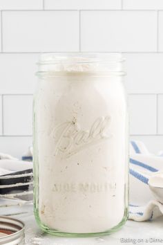 a mason jar filled with flour sitting on top of a counter next to other kitchen utensils