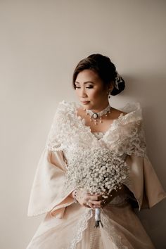 a woman in a wedding dress holding flowers