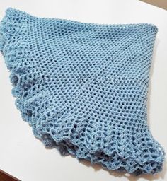 a blue knitted blanket laying on top of a table