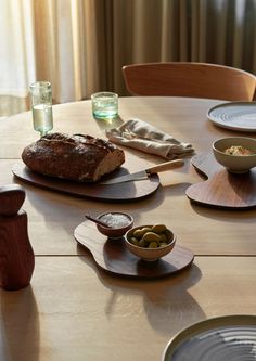 a wooden table topped with plates and bowls filled with food