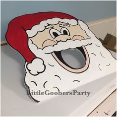 a close up of a santa clause mask on top of a table with paper cut outs