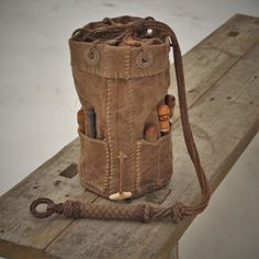 a brown bag sitting on top of a wooden table next to a roped cord