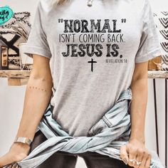 🚨Ready to make a statement? 🙌 Say it loud and proud with our Normal Isn't Coming Back Jesus Is unisex t-shirt! 💪 Show your faith and stand out from the crowd for only $23.95! 💸 Don't miss out on this must-have item! 😍 #JesusIs #FaithOverFear #BoldAndBlessed #ChristianTshirt #SpreadTheWord #UnisexFashion #NormalIsntComingBack #StatementPiece #TrendingNow #MustHave #Summertees #tanktops #craftycaseys #summertumblers #inspirationaltumblers Neck Women, Mom Tees, Jesus Is, Christian Clothing, Vintage Tops