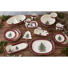 a table topped with plates and cups filled with christmas decorations on top of a wooden table