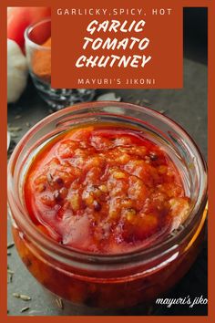 garlic and tomato chutney in a glass jar on a table with other ingredients