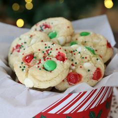 christmas cookies with candy and sprinkles in a paper container