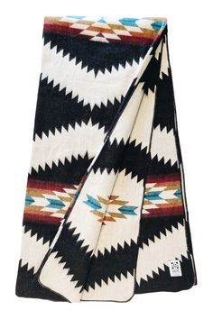 the pendleton blanket in black and white is folded on top of an orange, blue, and