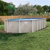 an above ground swimming pool in the middle of a yard with grass and trees around it