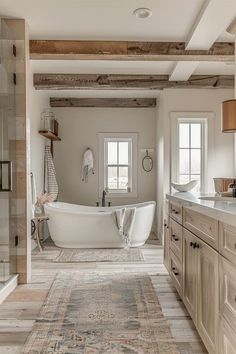 a bathroom with a bathtub, sink and rug on the floor in front of it