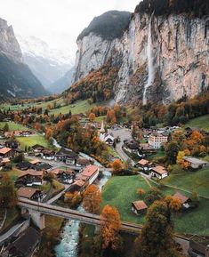 an aerial view of a small town in the mountains with a river running through it