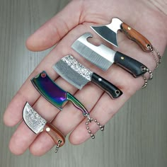 a person's hand holding five different types of knifes and knives on it