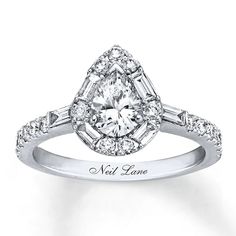 an engagement ring with a pear shaped diamond center surrounded by baguetts and diamonds