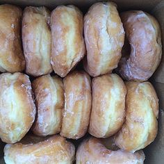 a box filled with glazed donuts sitting next to each other