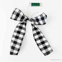 a black and white checkered ribbon tied to a piece of fabric with a green thread