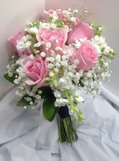 a bouquet of pink roses and white baby's breath