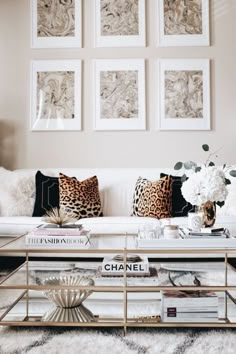 the living room is decorated in leopard print and white furniture with black pillows on top