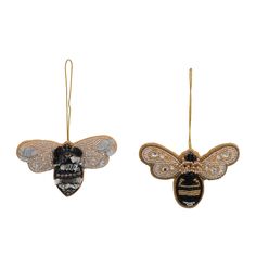 two bee ornament hanging from strings on a white background, one is black and the other is gold