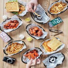 people are sitting at a table with plates of food