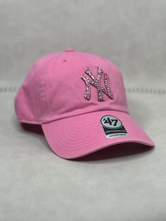 This is a pink tonal New York Clean Up adjustable hat that is hand embellished with pink Swarovski style crystals on the front logo. This hat features over 150+  Swarovski crystals.  - 100% Cotton - Matching fabric strap & buckle  - One Size Fits All - Raised Embroidered Logo - 150+ Swarovski pink crystals individually placed by hand - Ready to ship in 1 week from San Diego, CA Pink New York, Rhinestone Hat, Pink Swarovski, Pink Crystal, Adjustable Hat, Trucker Cap, One Size Fits All, Caps Hats, Swarovski Crystals