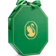 a green gift box with a gold swan on the front and bottom, tied in a bow