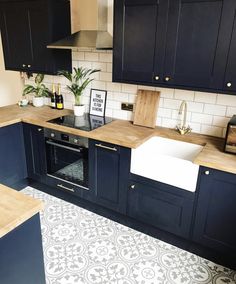 a kitchen with black cabinets and white tile flooring is seen in this image from above