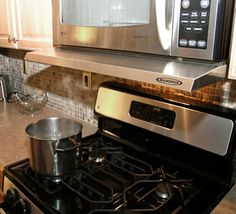 a stove top oven sitting inside of a kitchen next to a pot on the burner