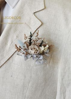 a boutonniere is adorned with flowers and leaves on a white suit jacket