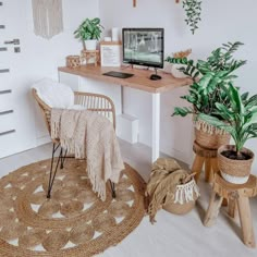 a home office with plants and wicker baskets on the wall, along with a computer