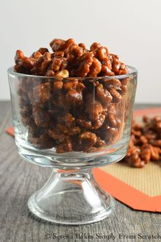 a glass bowl filled with nuts on top of a wooden table