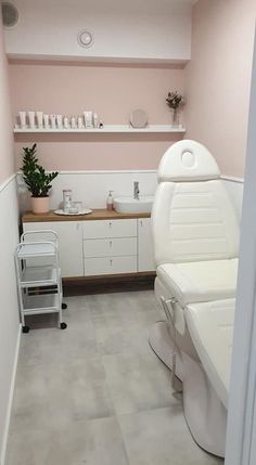 a room with a sink, chair and shelves on the wall in it's corner