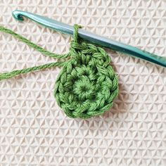 a green crochet hook with yarn on it