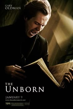 the unborn movie poster with a man laughing and holding an open book in his hands