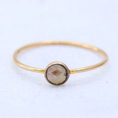 a close up of a gold ring with a stone in the center on a white background