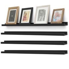 three black shelfs with pictures on them and two framed photos hanging from the top