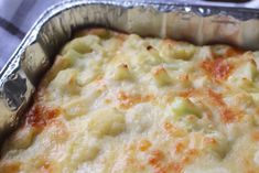 a casserole dish with cheese and vegetables in it