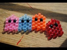 four different colored beads sitting on top of a wooden table