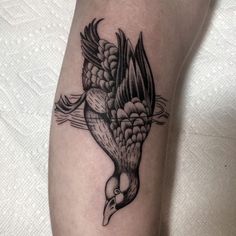 a black and white bird tattoo on the leg